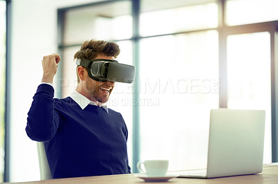 Buy stock photo Shot of a businessman wearing a VR headset and doing a fist pump while working in an office