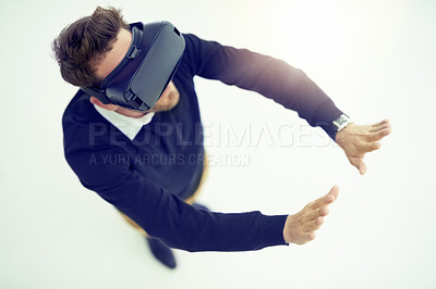 Buy stock photo High angle shot of a businessman wearing a VR headset in an office