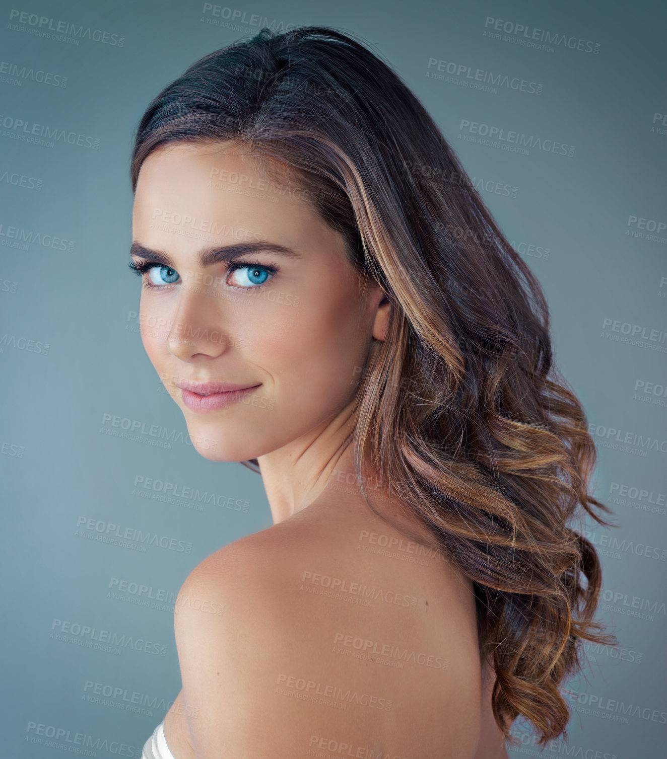 Buy stock photo Cropped portrait of a beautiful young woman posing against a grey background in the studio