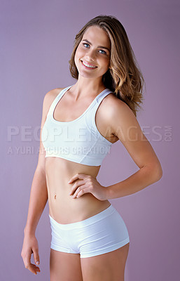 Buy stock photo Studio shot of a healthy young woman smiling and posing against a purple background