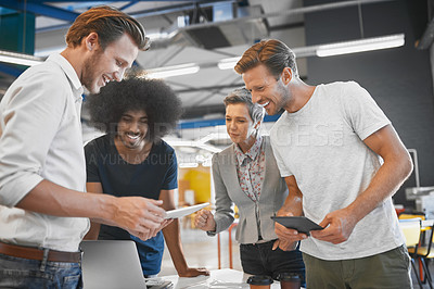 Buy stock photo Cropped shot of a handsome young businessman showing his colleagues something on a tablet