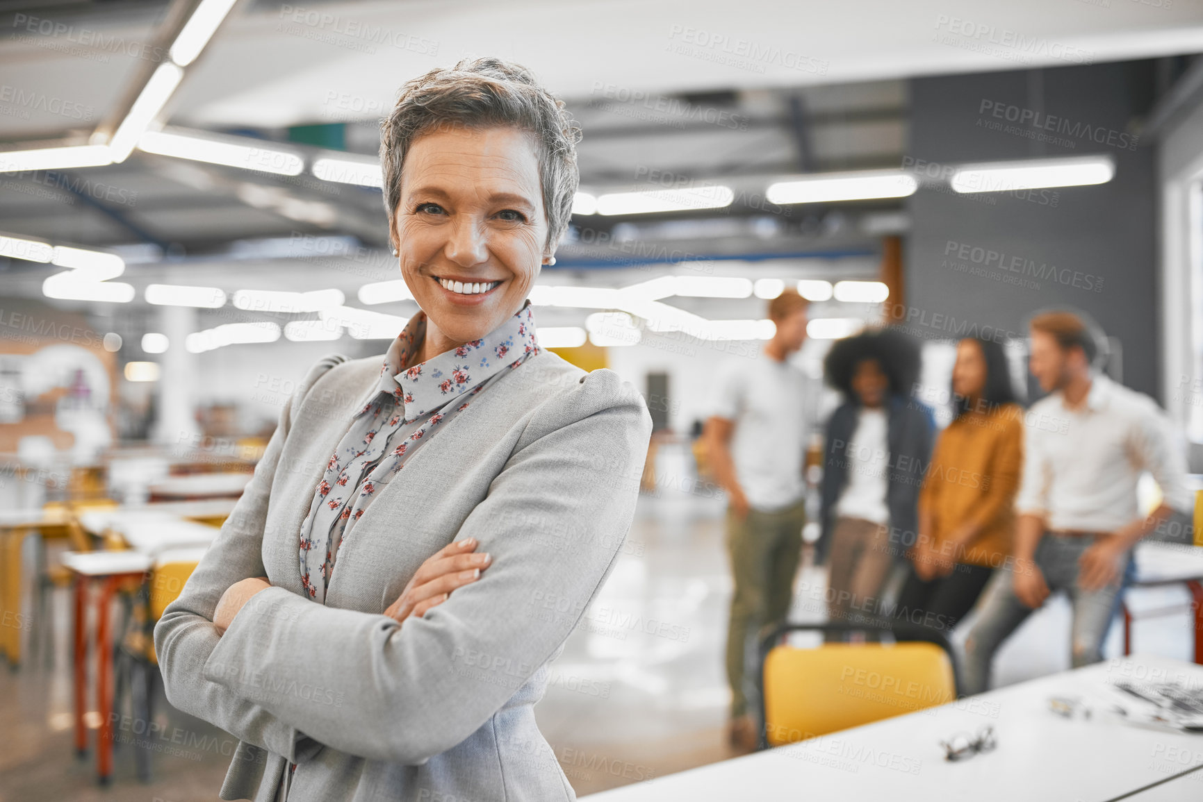 Buy stock photo Cropped portrait of an attractive mature businesswoman in the office with his colleagues in the background