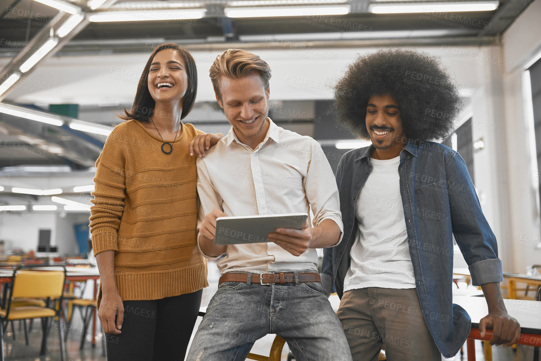 Buy stock photo Cropped shot of three young businesspeople looking at a tablet in their office
