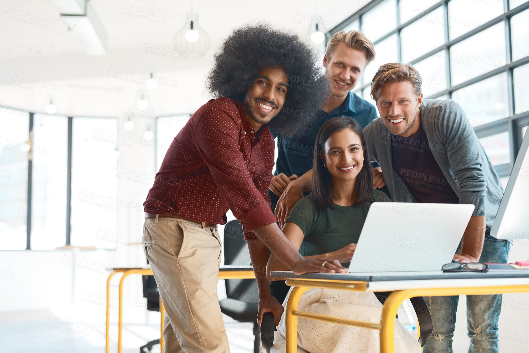 Buy stock photo Portrait of a team of happy designers working around a laptop in their modern office