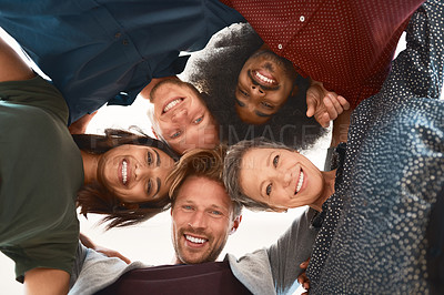 Buy stock photo Low-angle portrait of a team of happy designers posing with their heads in a huddle in the office