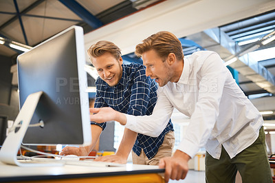 Buy stock photo Cropped shot of two young male designers working on a desktop in their office