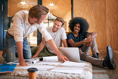 Buy stock photo Shot of a team of designers brainstorming on the floor in an office