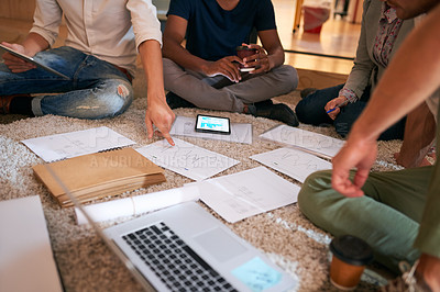 Buy stock photo Closeup shot of a group of unrecognisable businesspeople brainstorming on the floor in an office