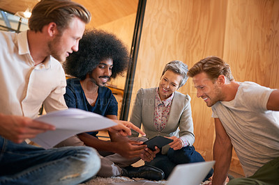 Buy stock photo Shot of a team of designers brainstorming on the floor in an office