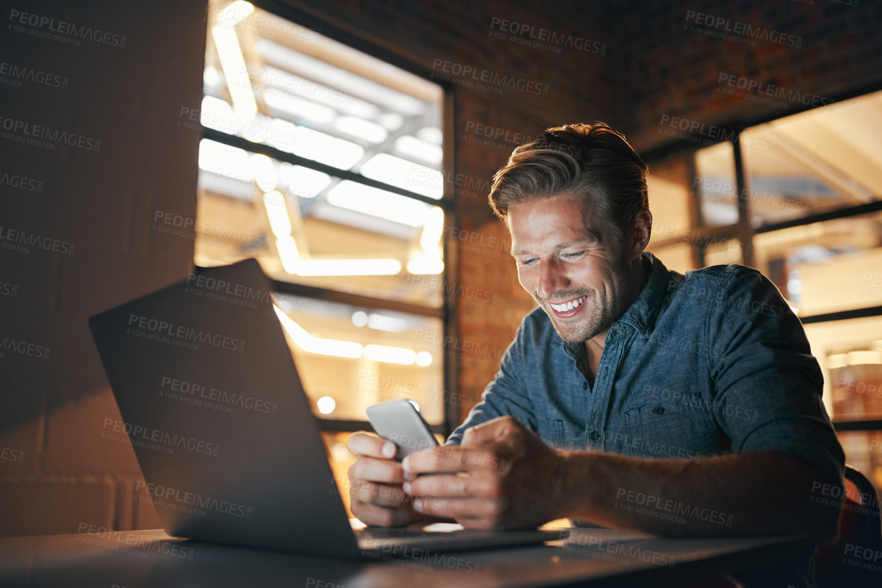 Buy stock photo Shot of a handsome young man working late in his office