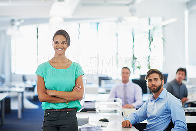 Buy stock photo Portrait of an attractive young businesswoman standing in an office with her colleagues in the background