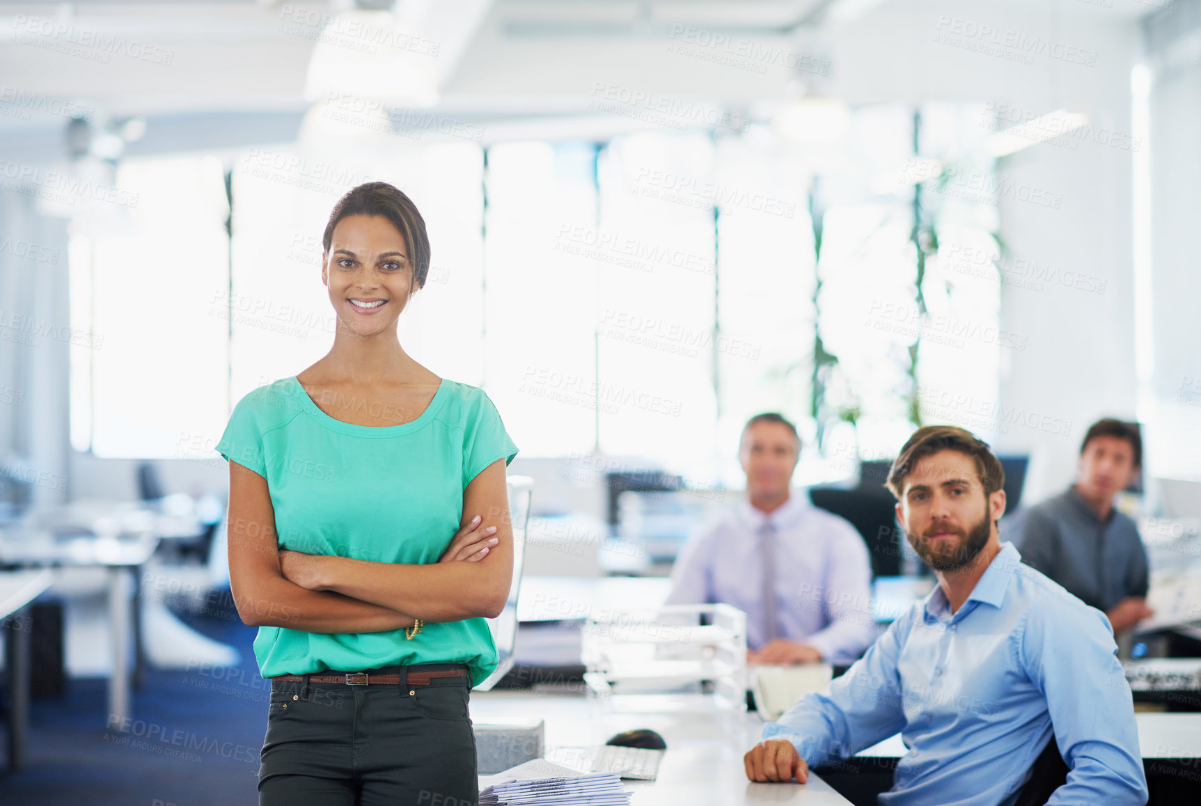Buy stock photo Portrait of an attractive young businesswoman standing in an office with her colleagues in the background