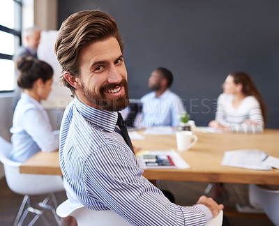 Buy stock photo Cropped portrait of a handsome young businessman sitting in the boardroom during a meeting