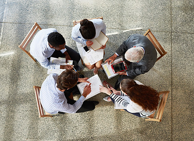 Buy stock photo High angle shot of a group of businesspeople working while sitting around in a circle