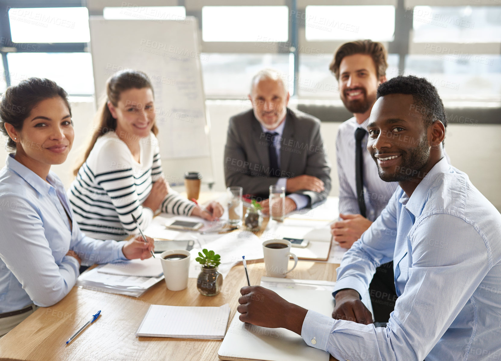 Buy stock photo Cropped portrait of a group of businesspeople sitting around a table in the boardroom