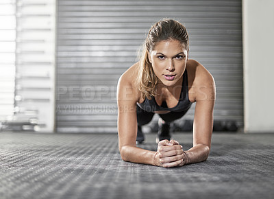 Buy stock photo Shot of a young woman doing a plank exercise at the gym