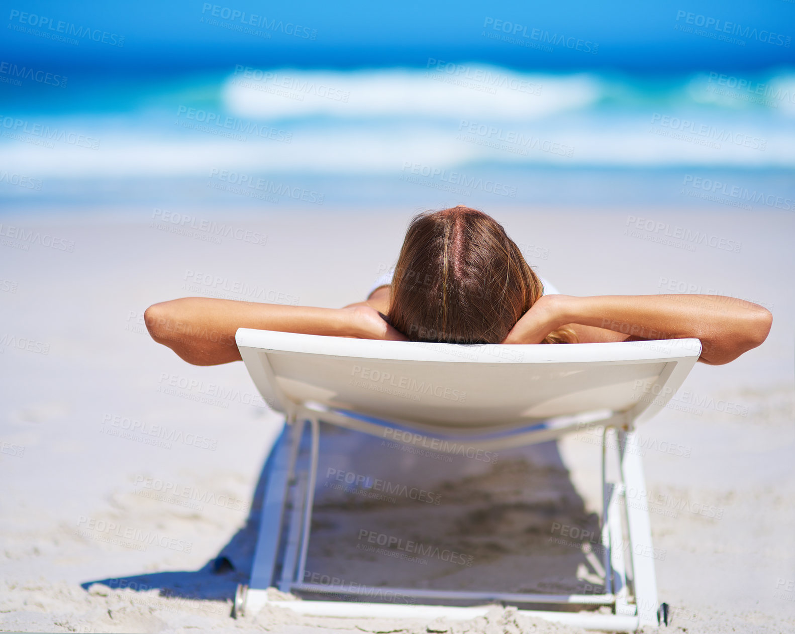 Buy stock photo Rearview shot of a young woman relaxing on the beach