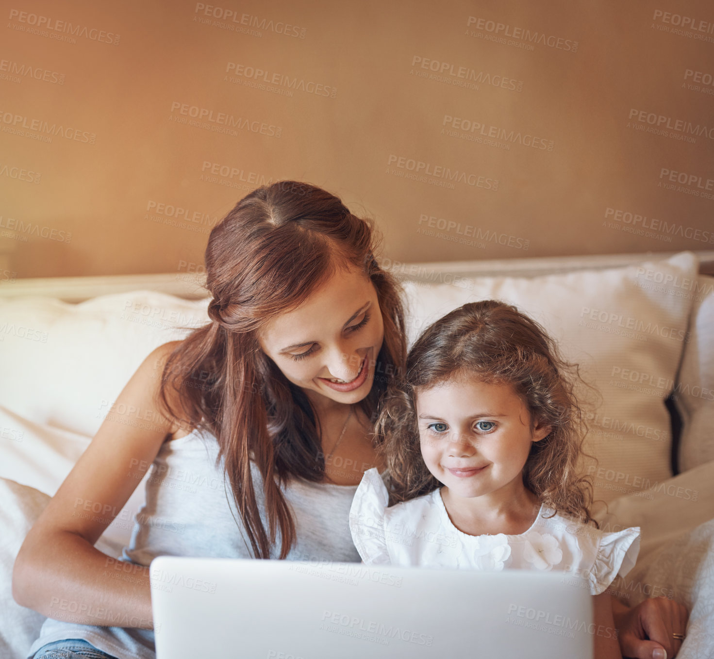 Buy stock photo Shot of a mother and her little daughter using a laptop together at home