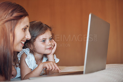 Buy stock photo Mother, girl child and laptop in bedroom for playing a game, educational cartoon or online video in home. Happy family, woman and kid on bed with technology for social media, bonding or watching film