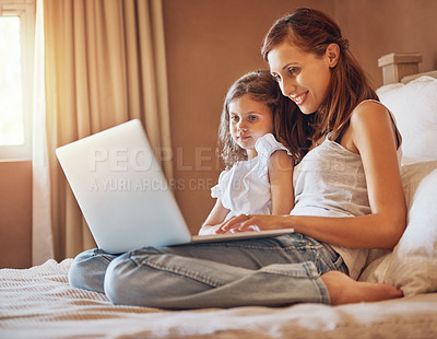 Buy stock photo Shot of a mother and her little daughter using a laptop together at home