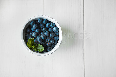 Buy stock photo Shot of fresh blueberries in a bowl on a white table