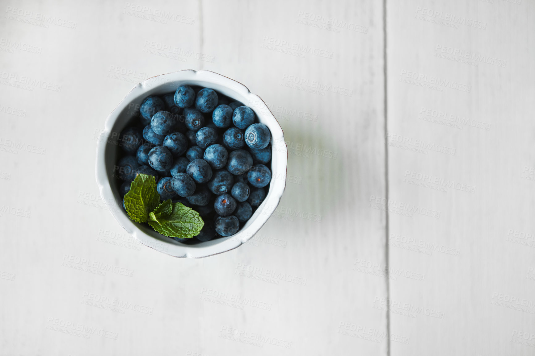 Buy stock photo Shot of fresh blueberries in a bowl on a white table