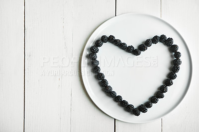 Buy stock photo High angle shot of blackberries in the shape of a heart on a plate