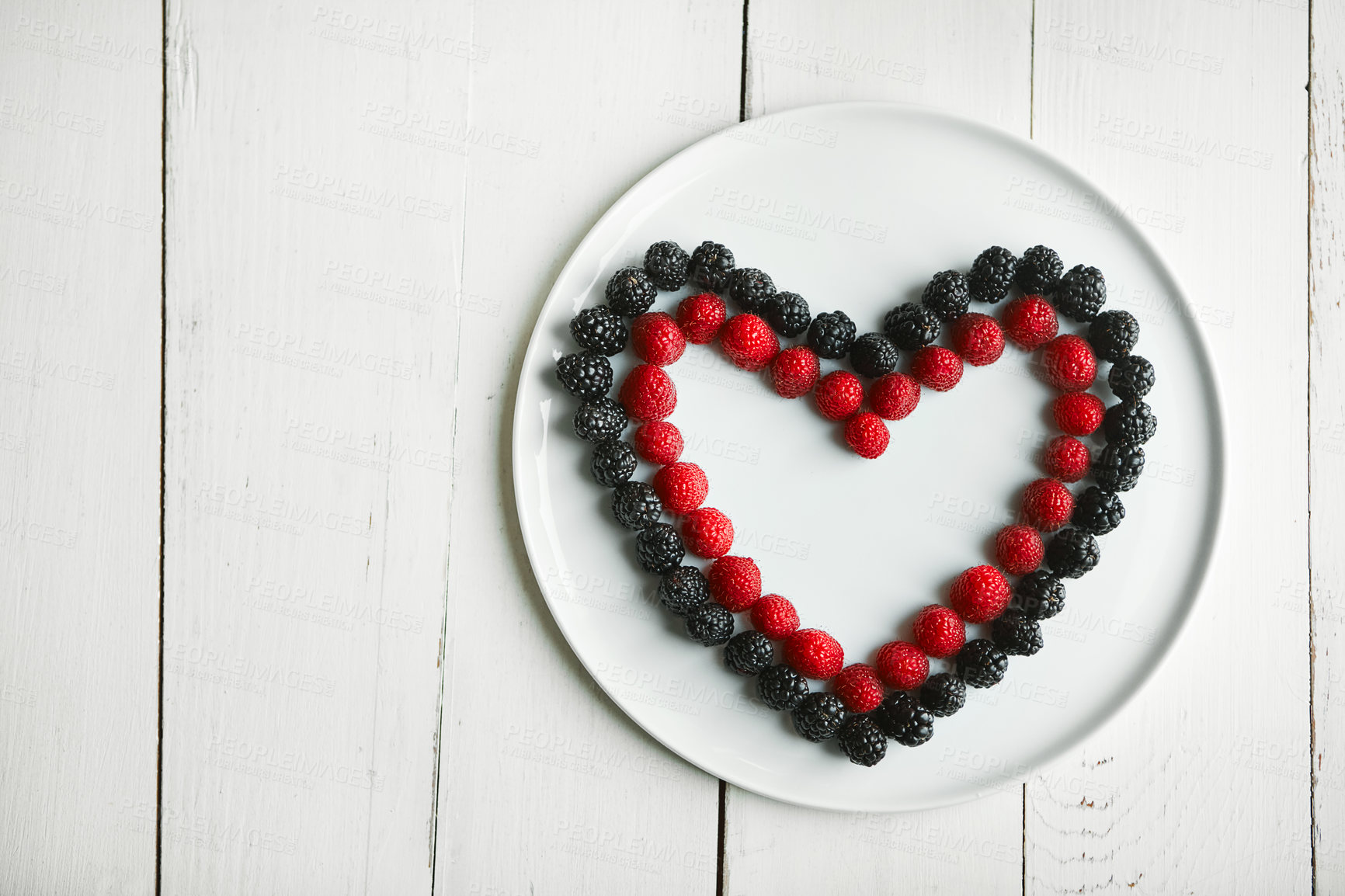 Buy stock photo High angle shot of berries in the shape of a heart on a plate