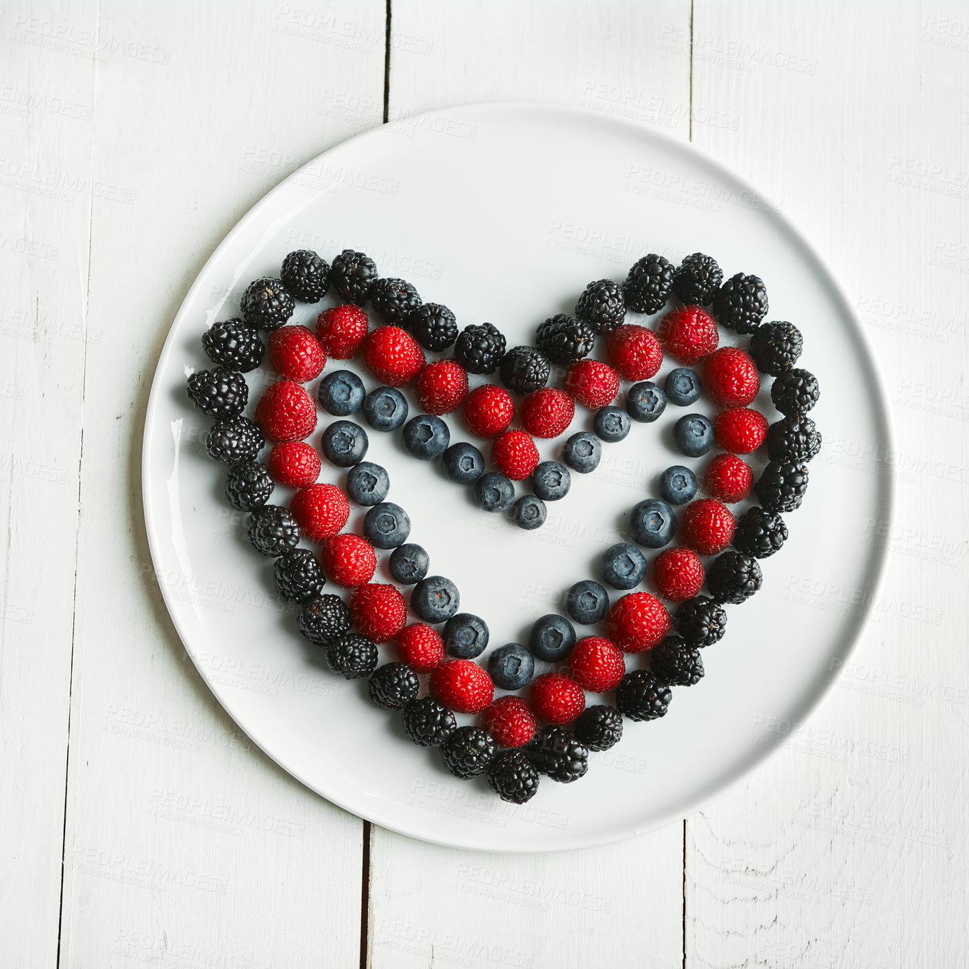 Buy stock photo High angle shot of berries in the shape of a heart on a plate