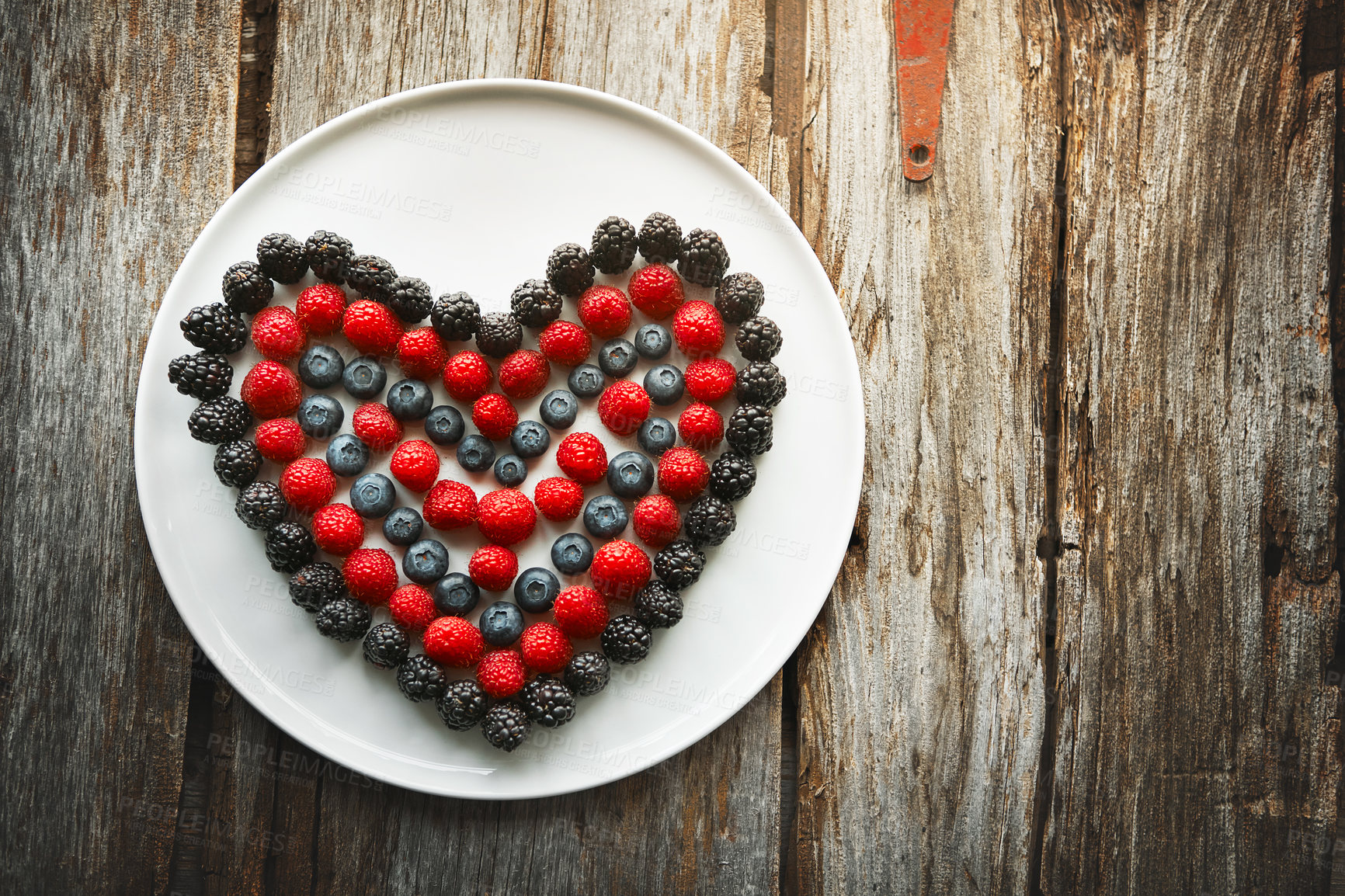 Buy stock photo High angle shot of berries in the shape of a heart on a plate