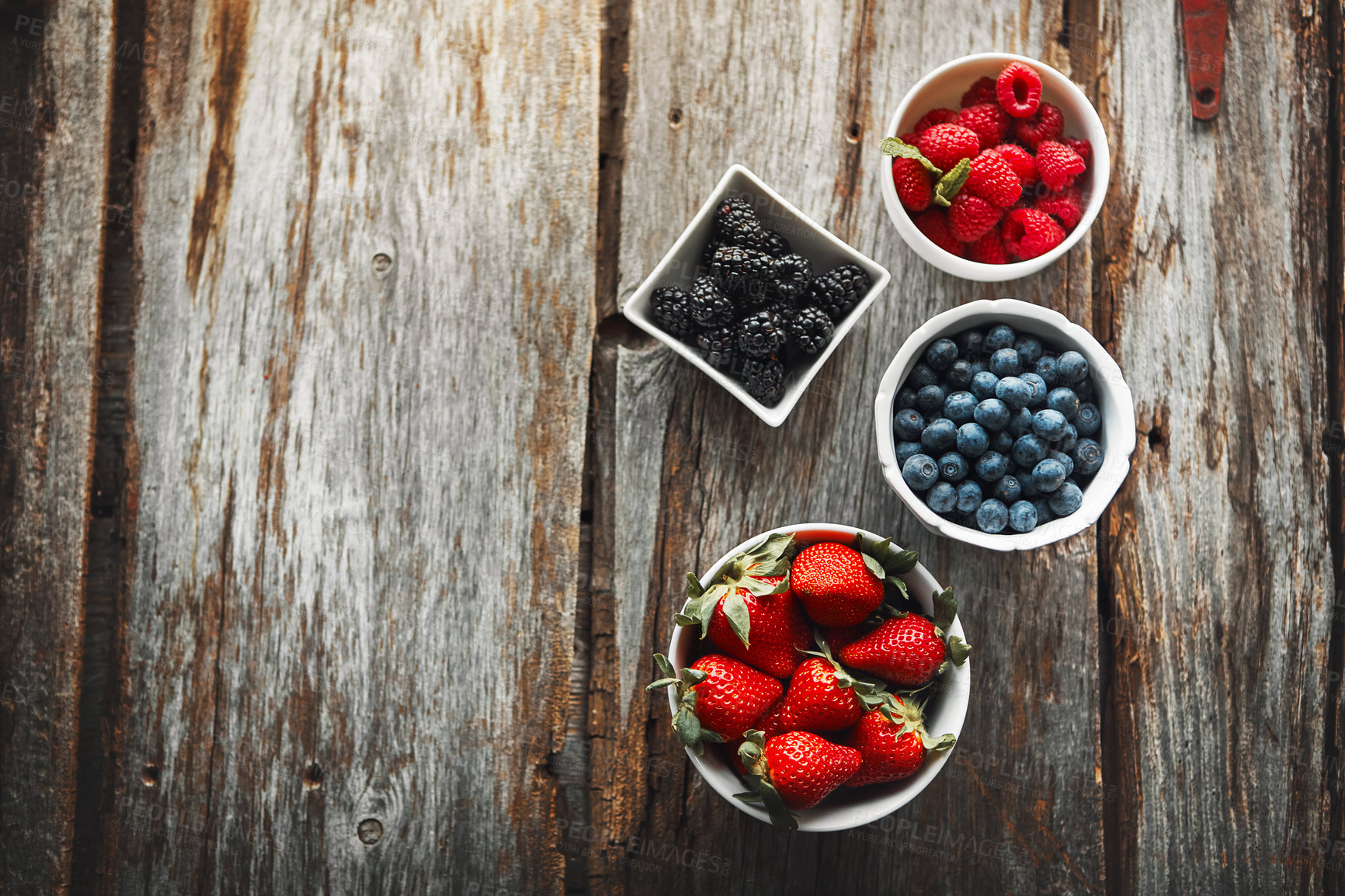 Buy stock photo Bowls, berries and above table in kitchen with organic choice for nutrition, breakfast and salad for wellness. Fruits, raspberry and strawberry in home with container, meal prep and food in morning