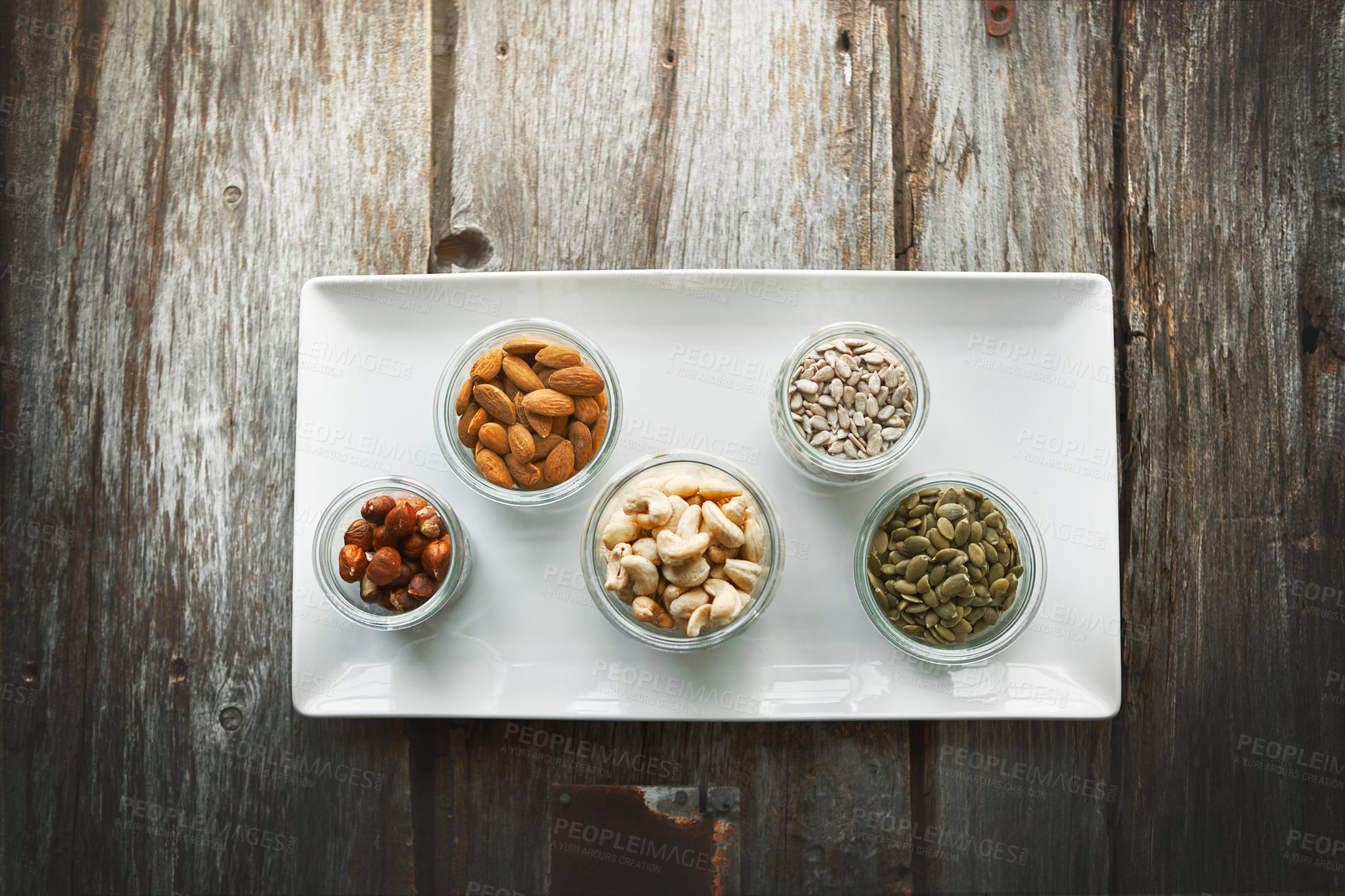 Buy stock photo High angle shot of bowls of various nuts on a table