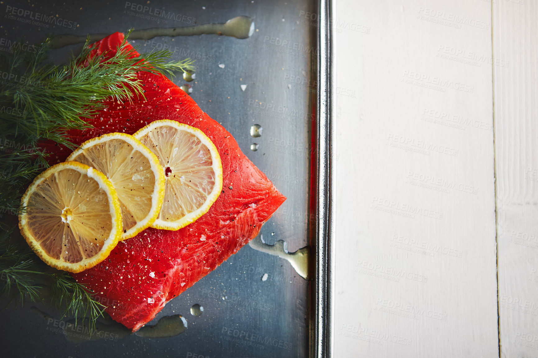 Buy stock photo Shot of a raw piece of meat garnished with slices of lemon