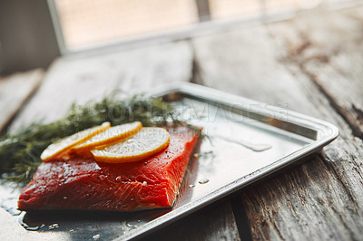 Buy stock photo Shot of a raw piece of meat garnished with slices of lemon