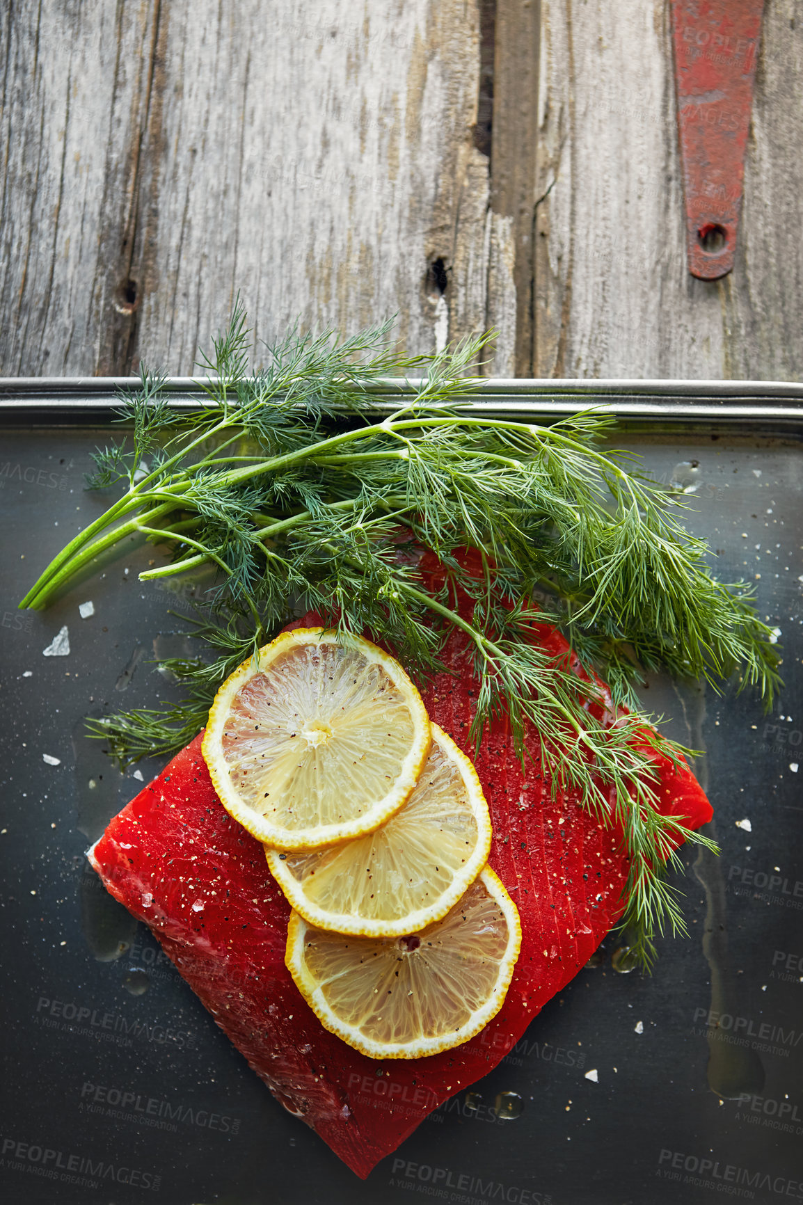 Buy stock photo Food, kitchen and lemon on fish on table for meal prep, lunch and dinner for pescatarian diet. Above, cooking and garnish on seafood for healthy eating, wellness and nutrition for protein or vitamins