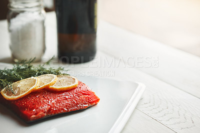 Buy stock photo Shot of a raw piece of meat garnished with slices of lemon