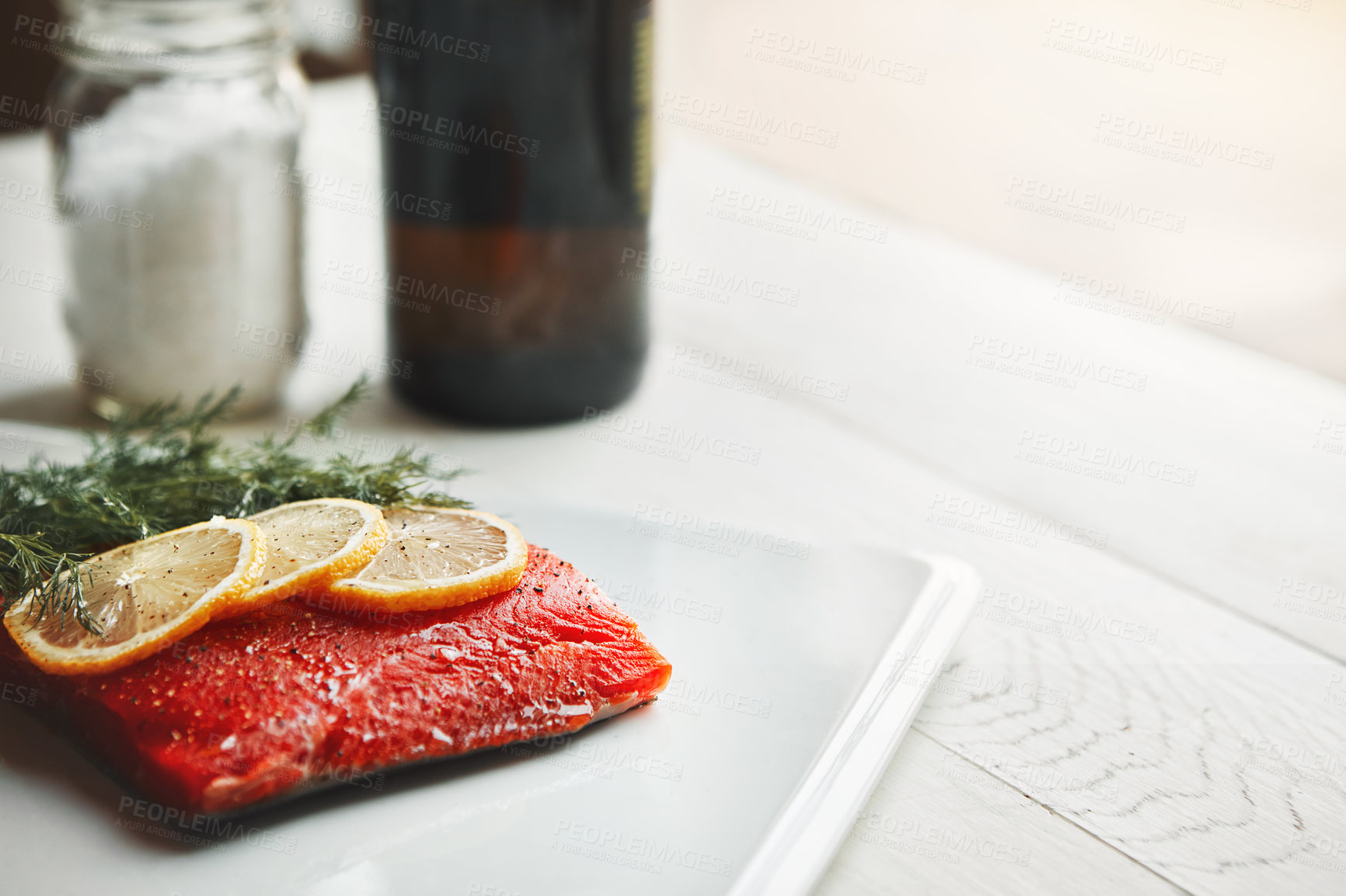 Buy stock photo Shot of a raw piece of meat garnished with slices of lemon