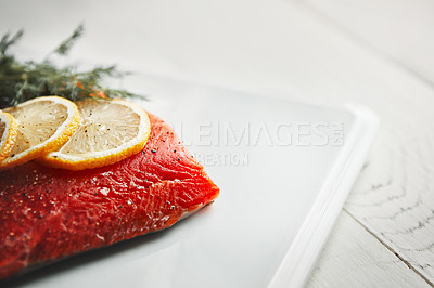 Buy stock photo Shot of a raw piece of meat garnished with slices of lemon