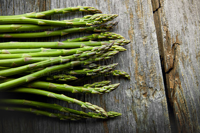 Buy stock photo Asparagus, kitchen and food on table for nutrition, lunch or product with wellness for health. Organic vegetable, cooking and above for benefit on counter, detox or meal prep for vegan diet in home