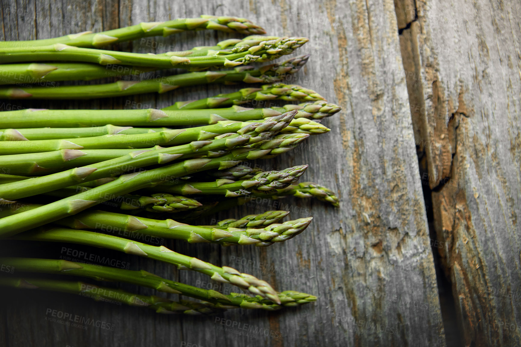 Buy stock photo Asparagus, kitchen and food on table for nutrition, lunch or product with wellness for health. Organic vegetable, cooking and above for benefit on counter, detox or meal prep for vegan diet in home