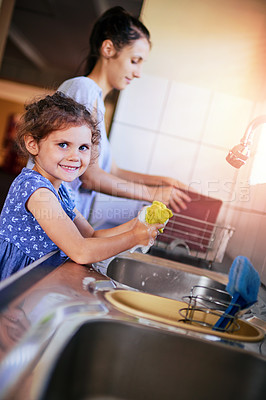 Buy stock photo Mother, girl and portrait for washing dirty dishes in home, learning hygiene and happy child in kitchen. Mom, daughter and cleaning plates in childhood routine, soap splash and helping with housework