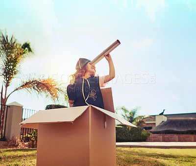 Buy stock photo Shot of a cute little girl in a pirate costume playing in a cardboard box in her backyard