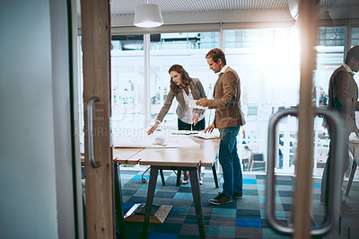 Buy stock photo Full length shot of two architects comparing blueprints while standing in their office