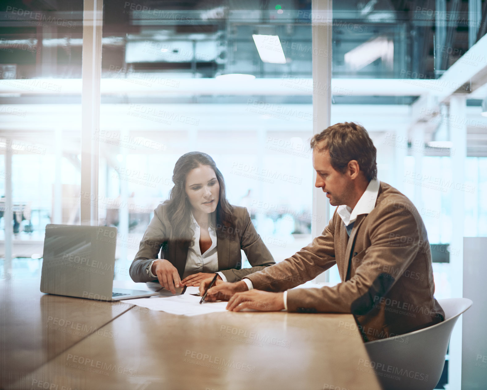 Buy stock photo Cropped shot of two businesspeople working together in the boardroom