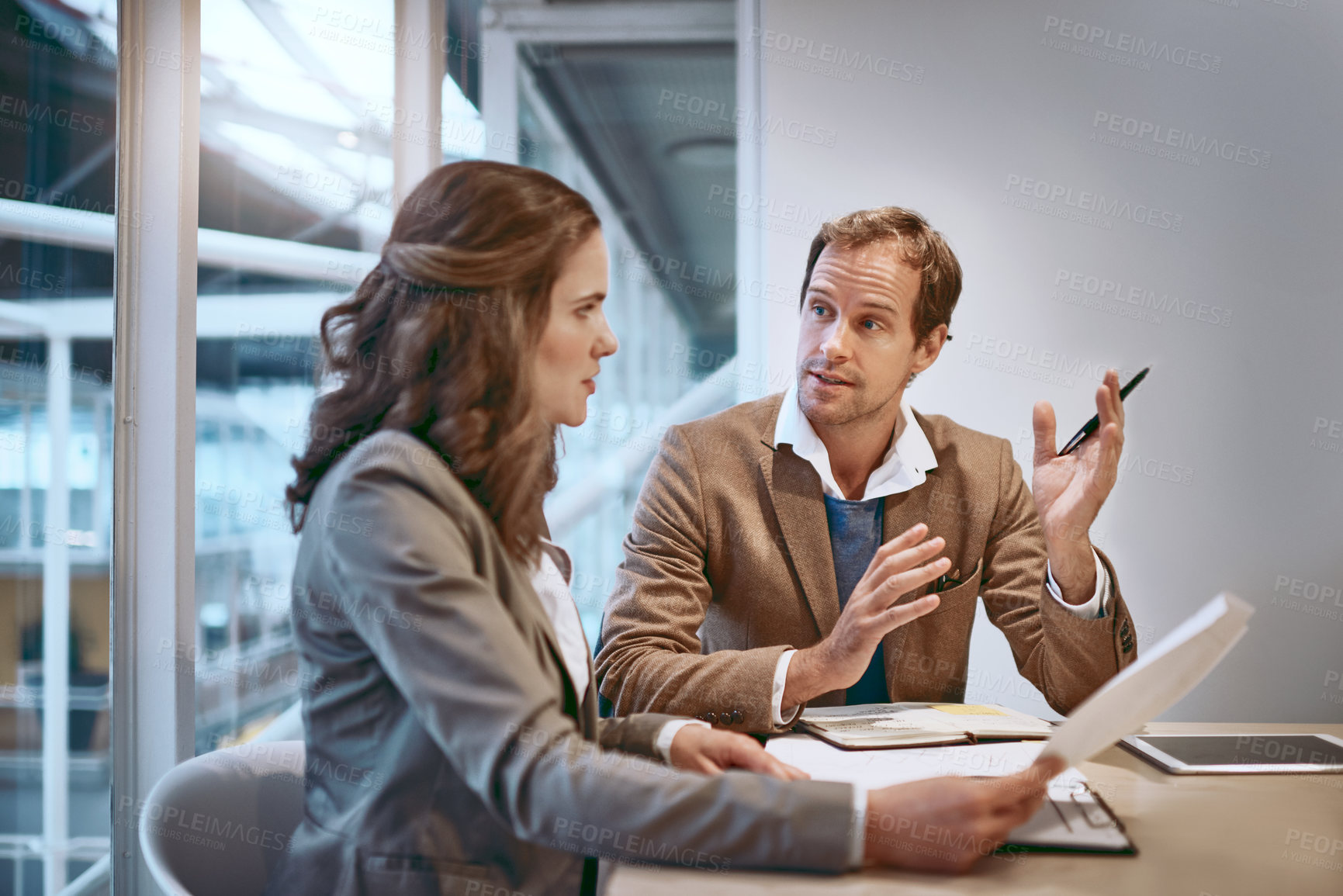 Buy stock photo Cropped shot of two businesspeople working together in the boardroom