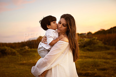Buy stock photo Shot of a son kissing his young mother on the cheek outdoors