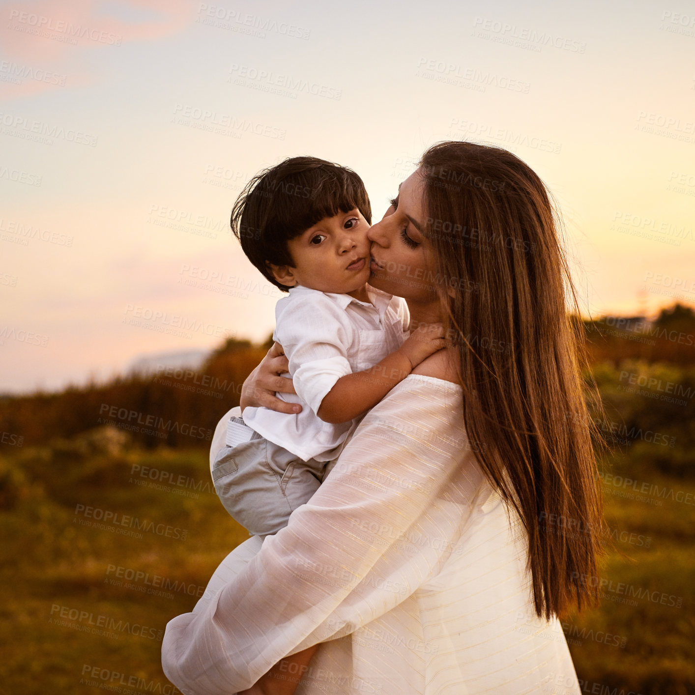 Buy stock photo Mother, kiss son and nature hug, countryside vacation and trust or security in relationship. Mama, boy and embrace in outdoor on holiday for support, love and affection for child or field bonding