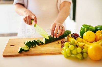 Buy stock photo Shot of an unrecognizable pregnant woman chopping fruit and vegetables at home