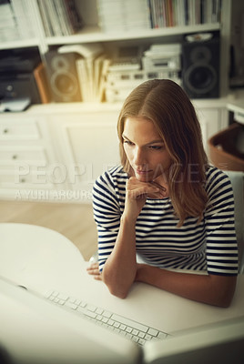 Buy stock photo High angle shot of a young woman working on a computer in her home office
