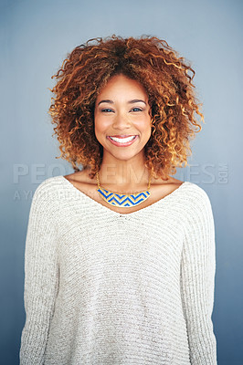 Buy stock photo Studio portrait of an attractive and happy young woman posing against a grey background